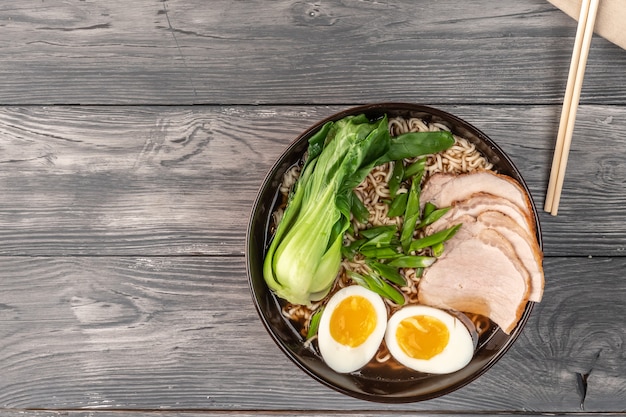 Nouilles instantanées avec tranches de porc et Bok choy. Vue de dessus. Copiez l'espace.