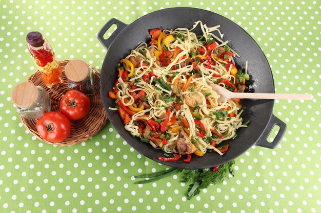 Des nouilles avec des légumes sur wok sur fond de tissu