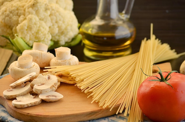 Nouilles longues ingrédients de tomate aux champignons pour les pâtes sur fond sombre