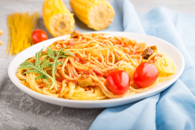 Nouilles de maïs à la sauce tomate sur fond de béton gris