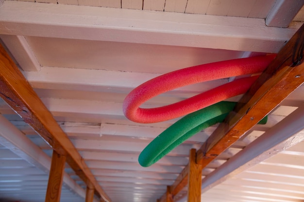 Nouilles de piscine aidant à nager parmi la planche de bois à l'étage supérieur du bateau.