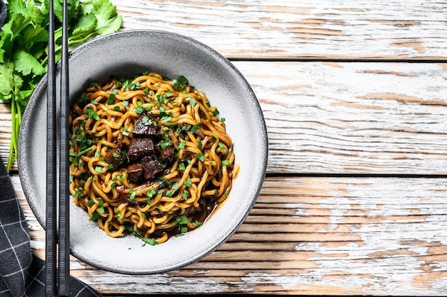 Nouilles ramen instantanées à la coriandre et au tofu dans une casserole en fonte. .