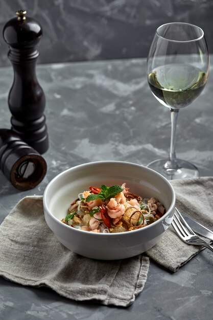 Nouilles de riz aux crevettes et fruits de mer, nouilles épicées de style asiatique dans un bol.