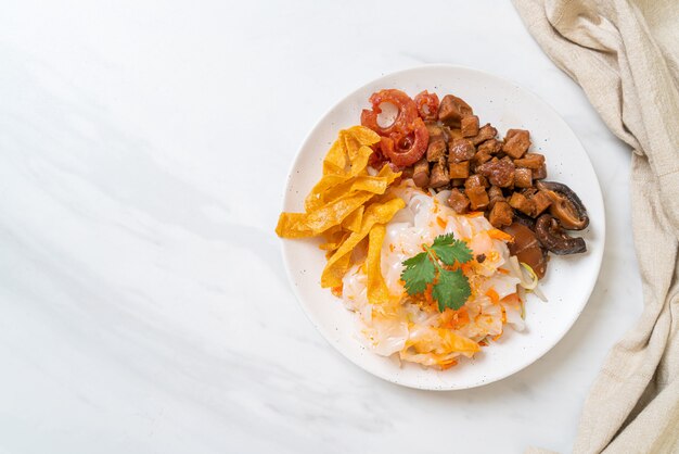 Nouilles de riz chinois à la vapeur avec du porc et du tofu à la sauce soja sucrée