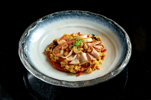 Nouilles De Riz En Verre En Sauce Aigre-douce Aux Crevettes, Pétoncles, Poulpe Et Calamars, Servies Dans Un Bol Blanc