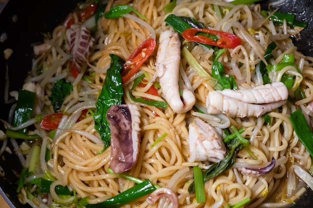 Nouilles sautées aux calamars sur une assiette à la maison