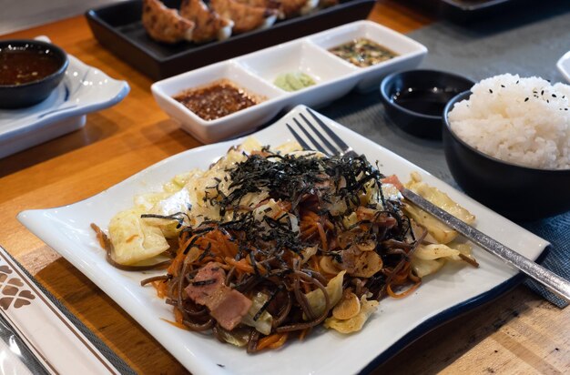 Nouilles sautées japonaises Yakisoba dans une assiette blanche sur fond de cuisine japonaise