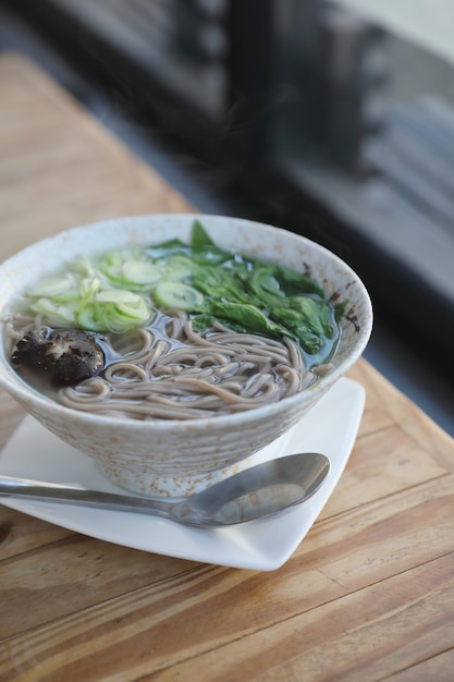 Nouilles soba avec soupe sur fond de bois