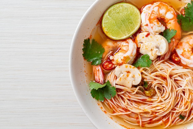 nouilles avec soupe épicée et crevettes dans un bol blanc (Tom Yum Kung) - style de cuisine asiatique