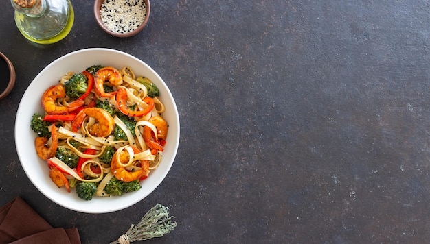 Des nouilles Udon avec des crevettes, des brocolis et des poivrons Cuisine asiatique