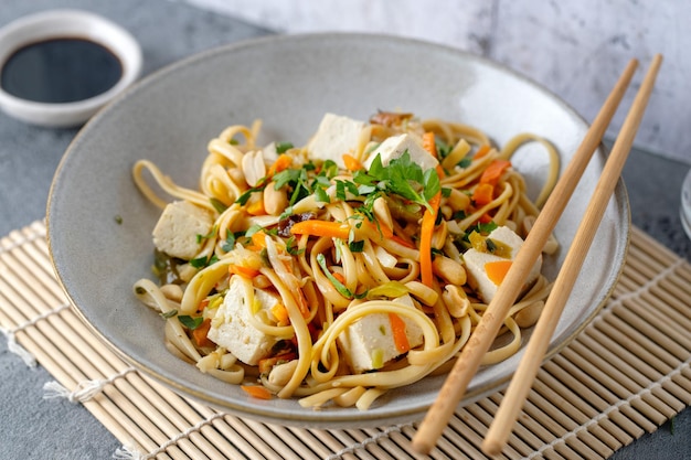 Des nouilles végétaliennes avec du tofu et des légumes