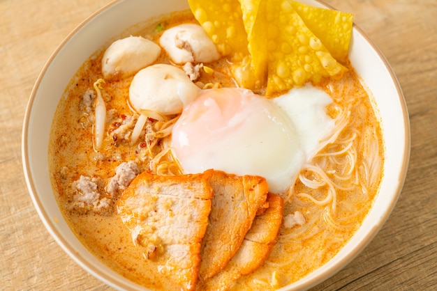 Nouilles de vermicelle de riz avec boulette de viande, porc rôti et œuf dans une soupe épicée - Tom Yum Noodles