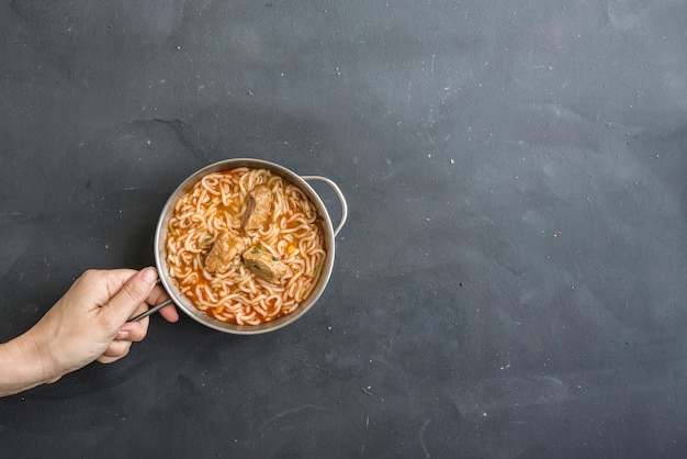 Nouilles à la viande de poulet dans un bol sur pierre sombre