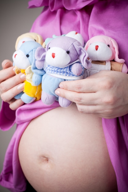 Nounours assis sur le ventre de femme enceinte