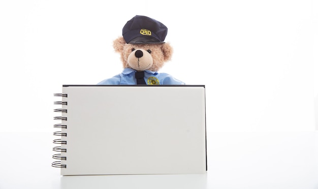 Nounours mignon en uniforme de policier isolé sur fond blanc