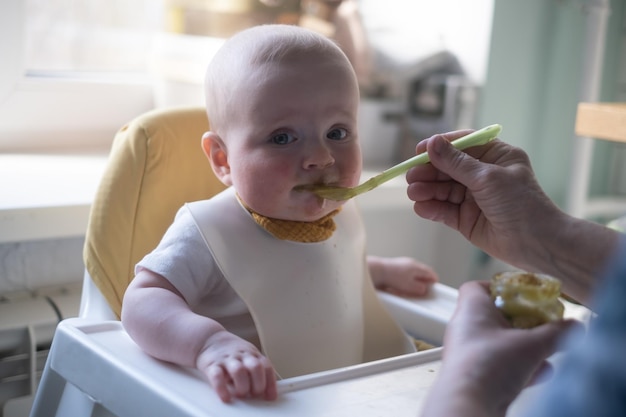 Nourrir un petit bébé caucasien pour la première fois