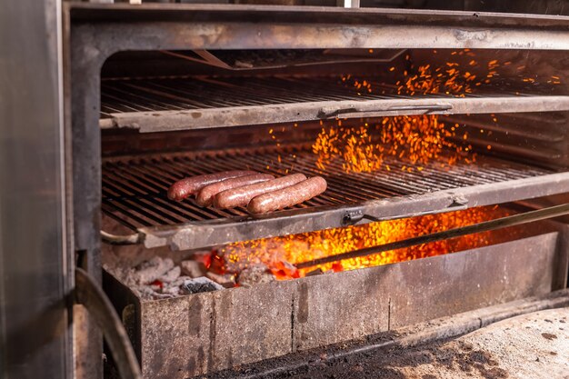 Nourriture, artisanat et concept délicieux - cuisson des saucisses sur un gril.