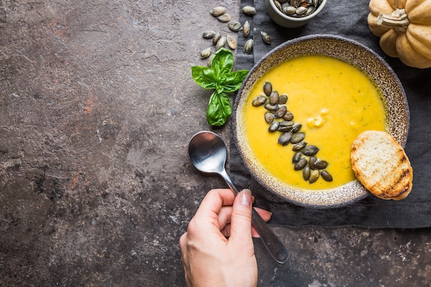 Nourriture d'automne de saison. Soupe de citrouille saine avec crème et graines de citrouille biologiques. Vue de dessus