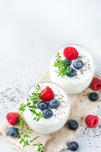 Nourriture et boisson alimentation saine et concept de régime Pudding de chia blanc fait maison avec des baies fraîches et du thym vert pour le petit-déjeuner sur une table de cuisine confortable Copier l'arrière-plan de l'espace