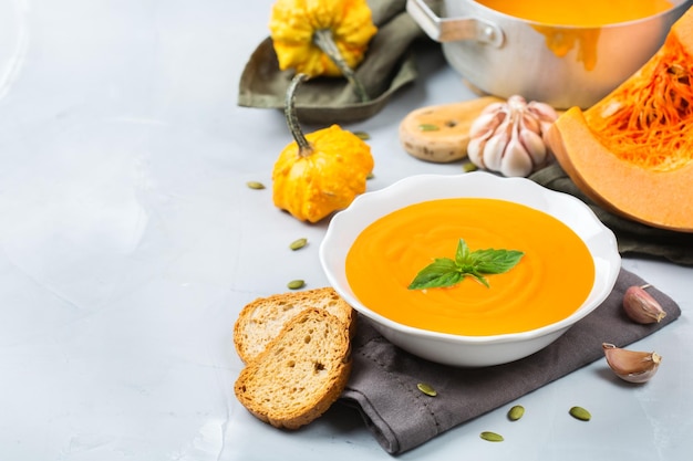 Nourriture et boisson nature morte régime et concept de nutrition automne saisonnier automne soupe de carottes à la citrouille orange rôtie avec des ingrédients sur une table copie espace fond confortable