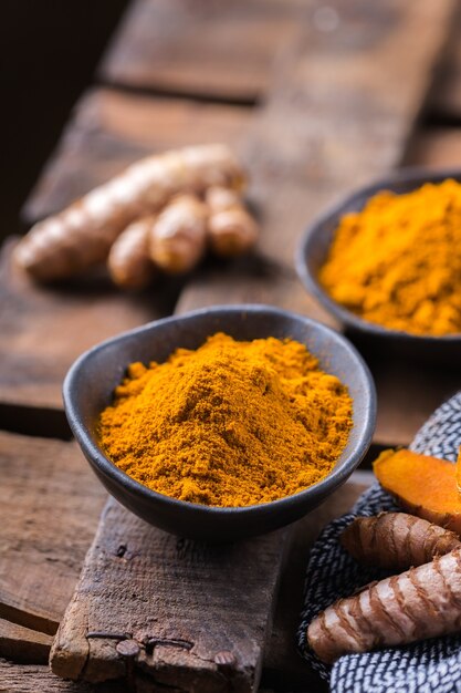 Nourriture et boisson, nutrition diététique, concept de soins de santé. Racine et poudre de curcuma orange biologique crue, curcuma longa sur une table de cuisson. Épices orientales indiennes à faible teneur en cholestérol