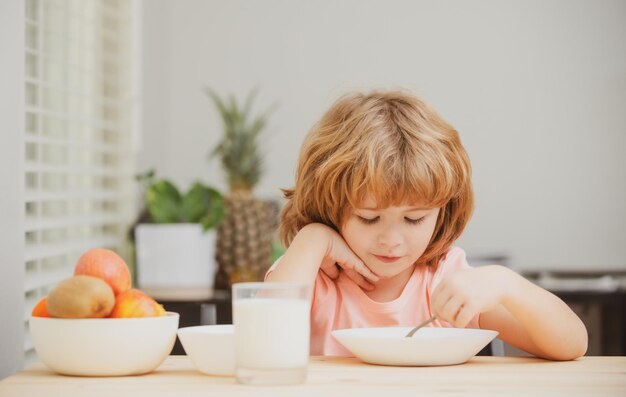 Nourriture et boisson pour les enfants caucasien tout-petit enfant garçon mangeant une soupe saine dans la cuisine