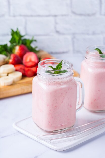 Nourriture et boisson régime alimentaire sain et mode de vie nutritionnel végétalien concept végétarien alcalin Smoothie rose avec banane et fraise sur une table de cuisine moderne Copier l'arrière-plan de l'espace