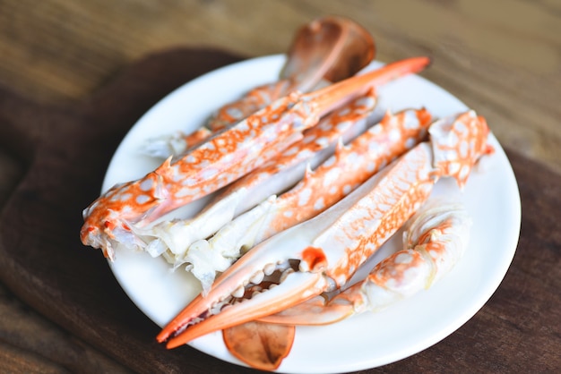 Nourriture bouillie de crabe sur la plaque blanche sur la table, fruits de mer de fruits de mer de griffes de crabe, crabe bleu de nageur