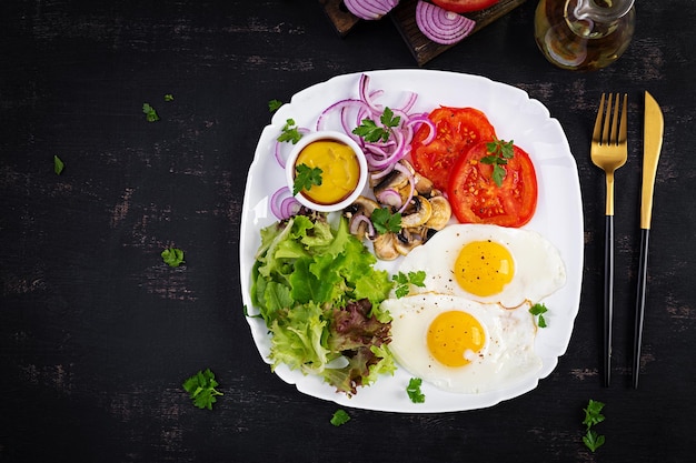 Nourriture cétogène Oeufs frits champignons et tomates en tranches Petit-déjeuner paléo Keto Vue de dessus espace de copie au-dessus