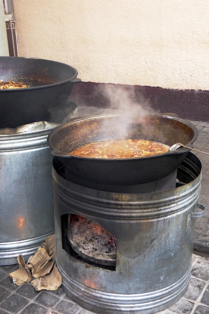 Nourriture dans un chaudron cuit sur du bois de chauffage