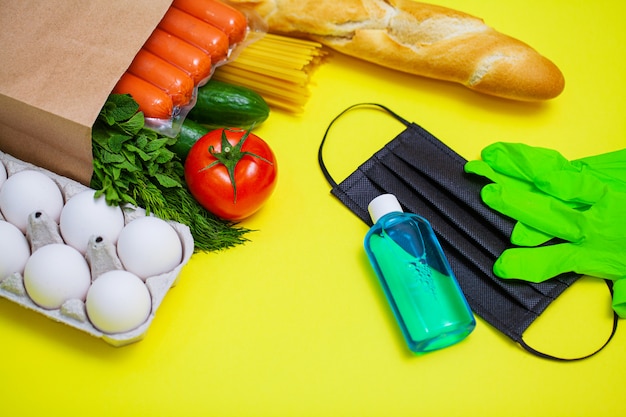 Photo nourriture dans un sac en papier avec masque médical et bouteille de gel