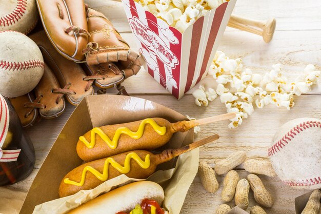 Photo nourriture de fête de baseball avec des balles et des gants sur une table en bois.