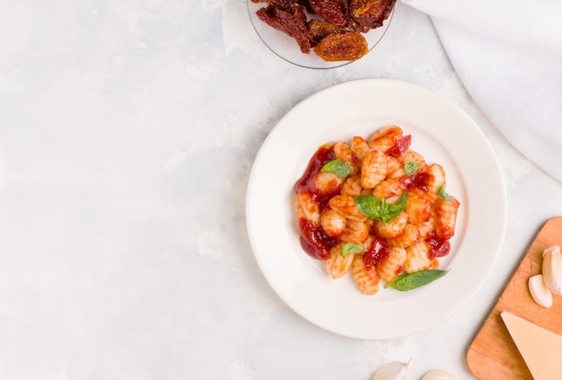 Nourriture italienne. Les gnocchis sont un plat traditionnel de pommes de terre à la sauce tomate et au basilic sur une assiette blanche. Espace de copie