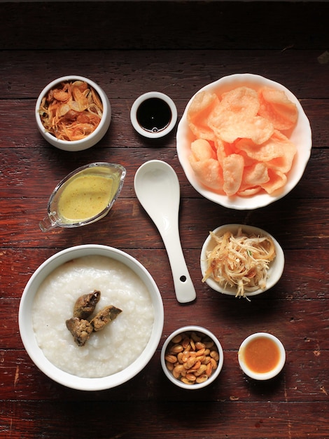 Nourriture Knolling Concept Bubur Ayam ou bouillie de riz indonésienne avec poulet râpé. Servi avec Kerukpuk (craquelins), sauce soja, fèves de soja frites et sambal