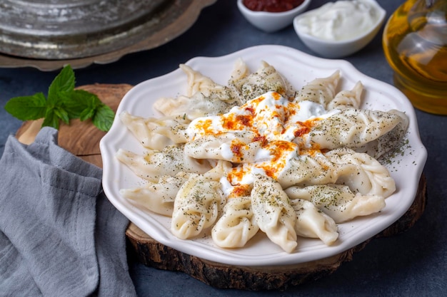 Nourriture manti traditionnelle sur assiette, vue de dessus. Le concept de cuisine orientale. Boulettes de manty alimentaires ouzbeks. (nom turc ; hinkel mantisi + cecen manti)