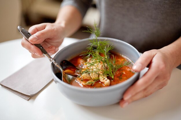 nourriture, nouvelle cuisine nordique et concept de personnes - femme mangeant de la soupe de fruits de mer avec du poisson et des moules bleues au café ou au restaurant