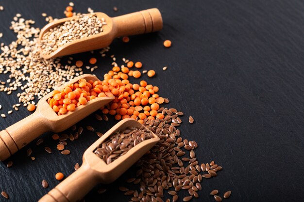 Nourriture nutritionnelle saine Graines de lin, de sésame et de lentille orange dans une cuillère en bambou avec espace de copie