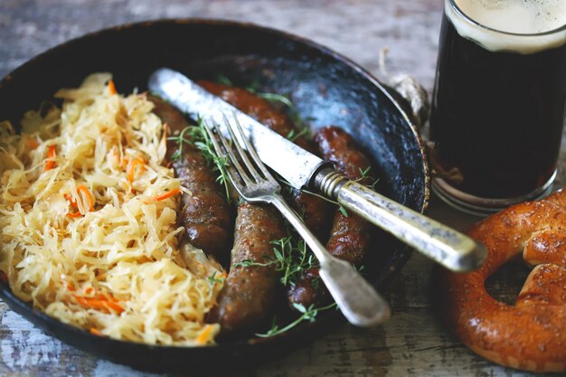 Nourriture d'Oktoberfest. Saucisses bavaroises chaudes avec choucroute dans une casserole. Délicieuse cuisine du festival de la bière