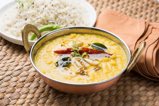 Nourriture populaire indienne Dal Fry ou Dal Tadka Curry traditionnel servi avec du riz jeera, isolé sur fond blanc, mise au point sélective