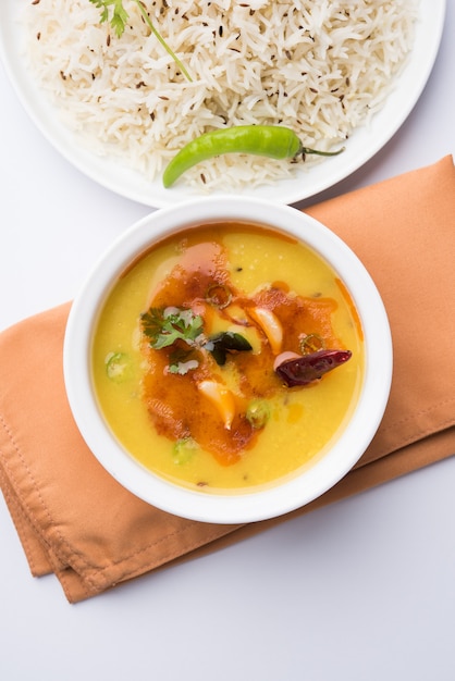 Nourriture populaire indienne Dal Fry ou Dal Tadka Curry traditionnel servi avec du riz jeera, isolé sur fond blanc, mise au point sélective