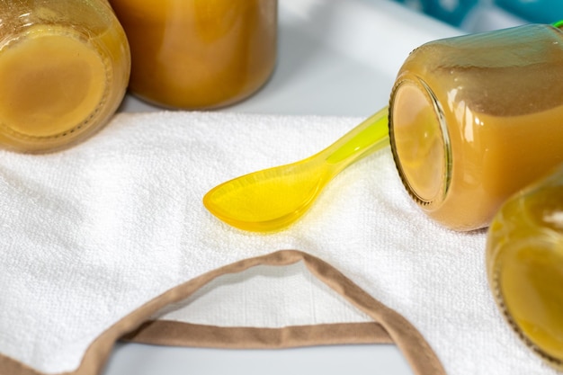 Nourriture pour bébé en bocaux et cuillère en silicone de couleur vert doux Purée de fruits ou de légumes frais sur tout-petit