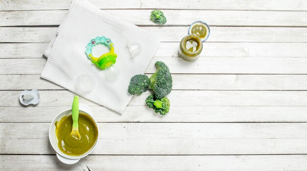 Nourriture pour bébé Purée de bébé de brocoli sur un fond en bois blanc