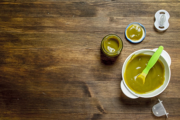 Nourriture pour bébés. Purée de bébé de brocoli. Sur un fond en bois.