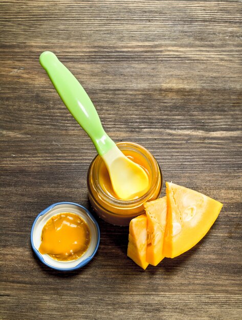 Photo nourriture pour bébés. purée de bébé de citrouille fraîche. sur une table en bois.