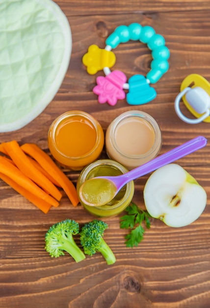 Nourriture pour bébés. Purée de légumes et fruits en bocaux. Mise au point sélective.