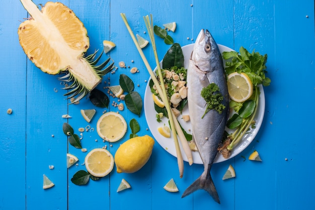 Nourriture pour poissons avec des ingrédients épices sur la table bleue