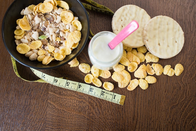 Nourriture saine, cornflakes en assiette et verre avec yaourt