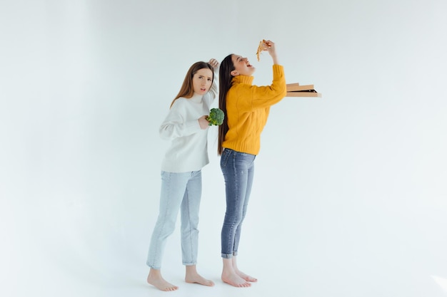 Nourriture saine. Une femme tient une pizza et l'autre un brocoli