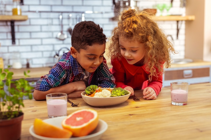 Photo la nourriture saine. garçon énigmatique se penchant sur la table en allant dîner