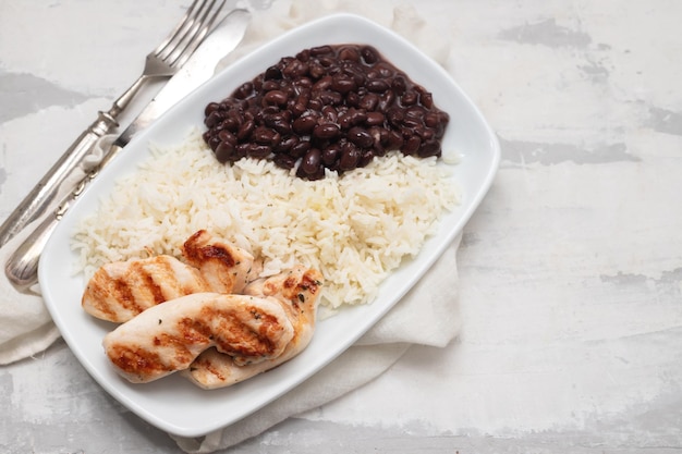 Nourriture saine avec des haricots de poitrine de poulet et du riz sur une assiette blanche